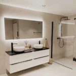 Utrolig flott bad med doble servanter og lys bak speil